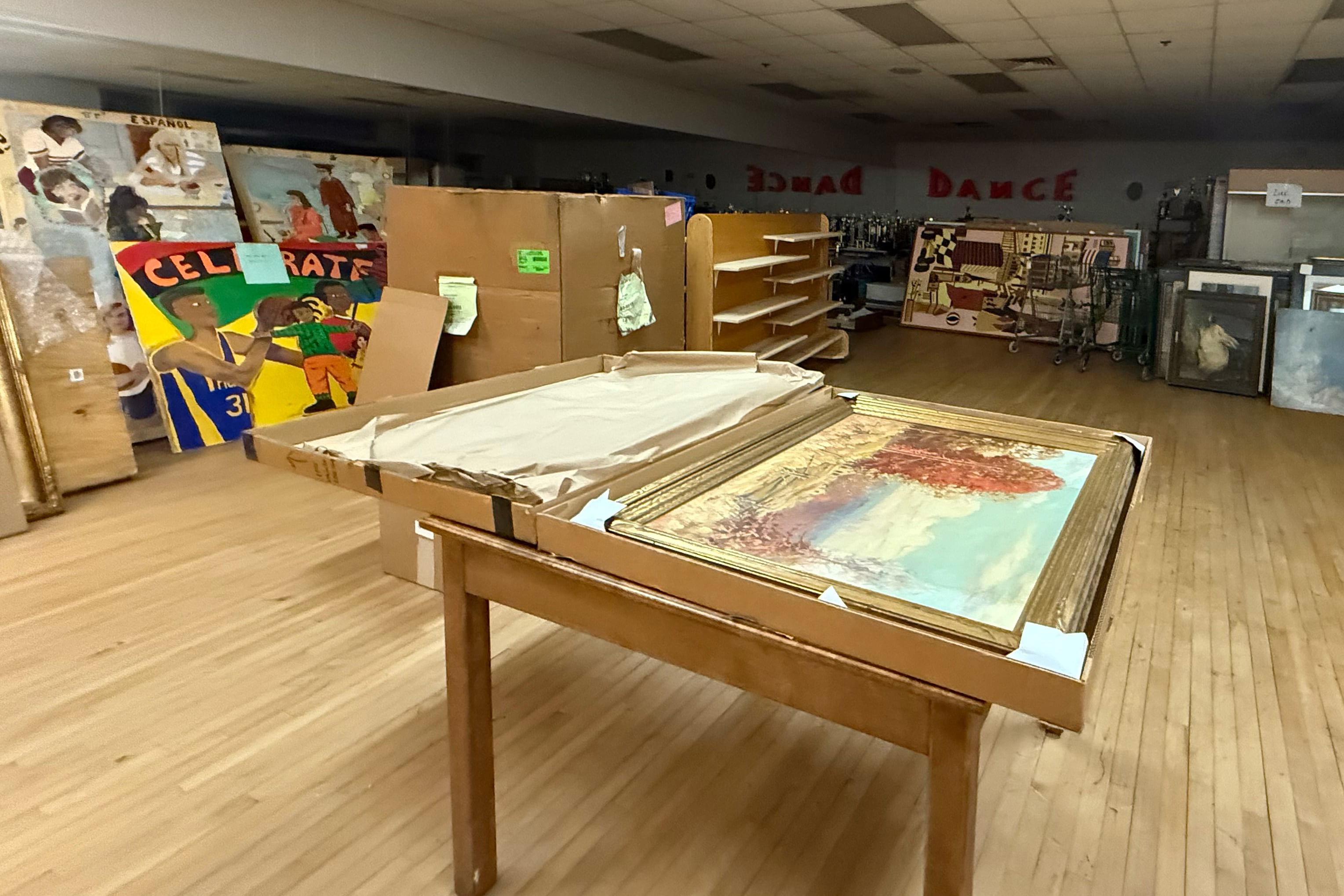 A photograph of a room full of artwork wrapped in paper or cardboard.