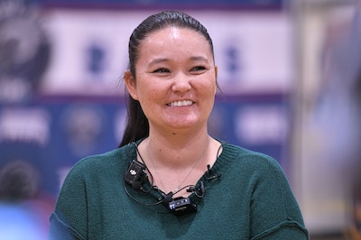A portrait of a woman with a green top.