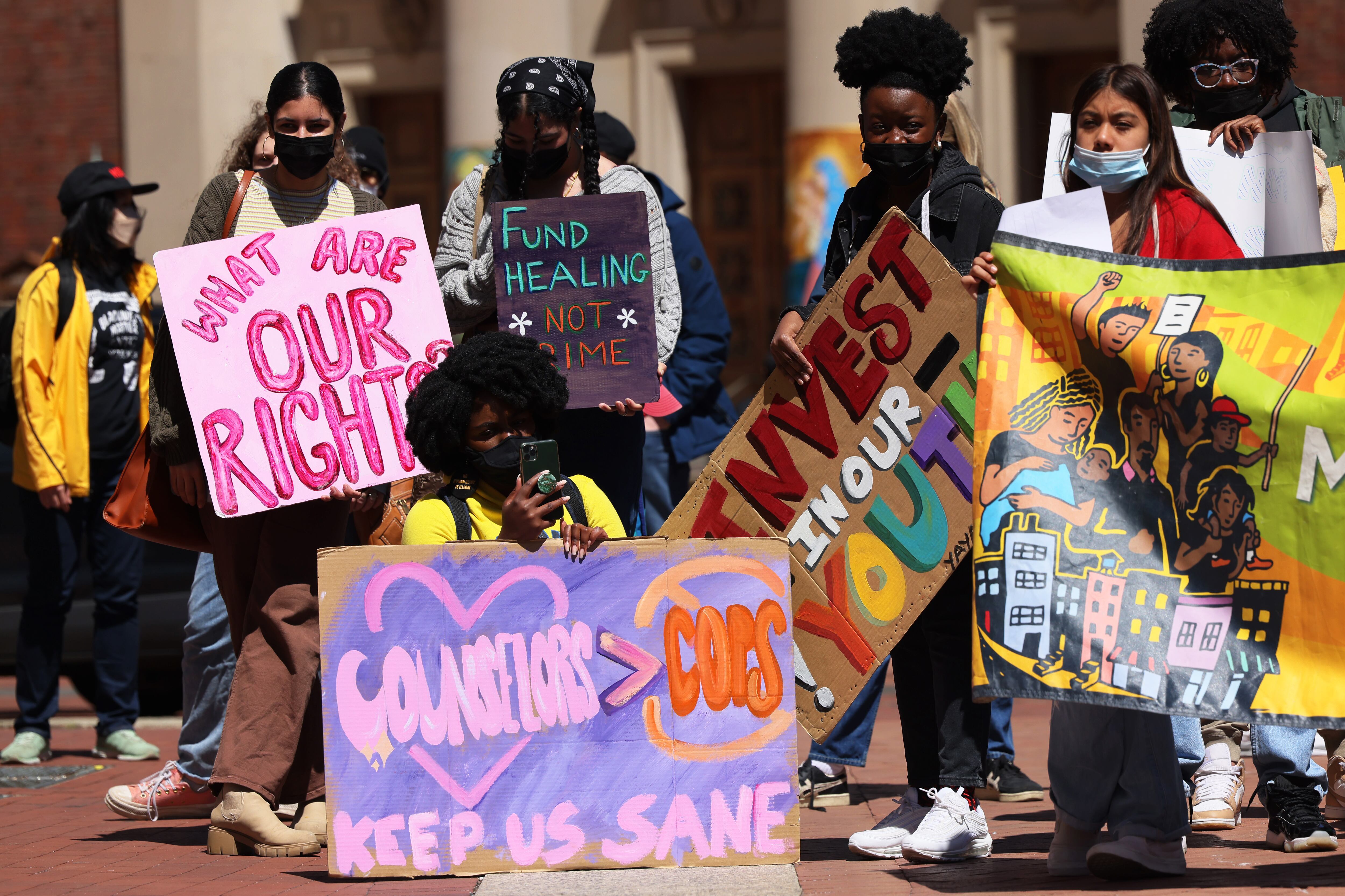 Students hold colorful signs during a rally