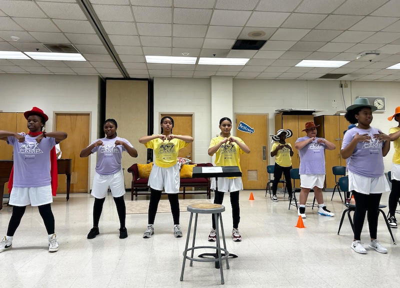 A group of students practice dancing in a studio.