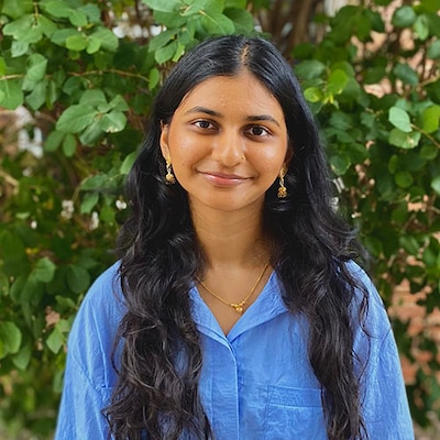 Headshot of a teenage girl with long black hair. She wears a blue shirt.