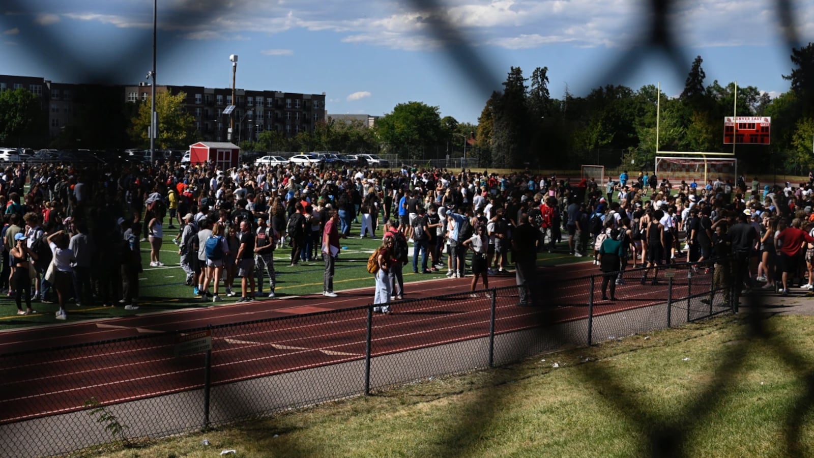 Students gather outside as Denver police respond to a report of a threat at East High School.