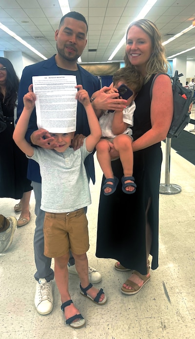 A man stands with a woman and two boys