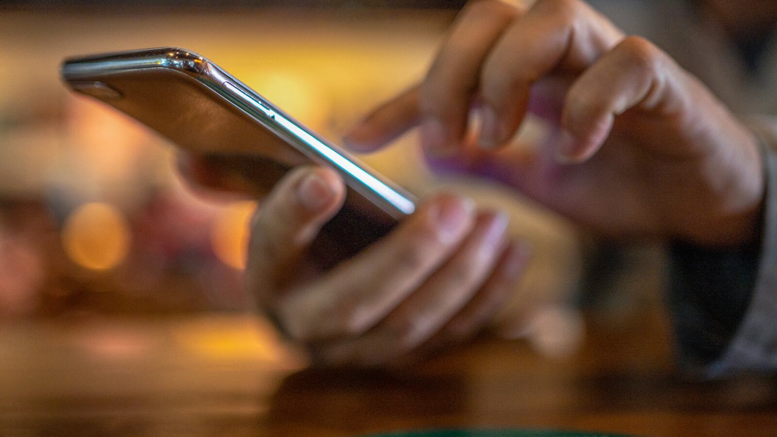A woman scrolls on her smartphone.