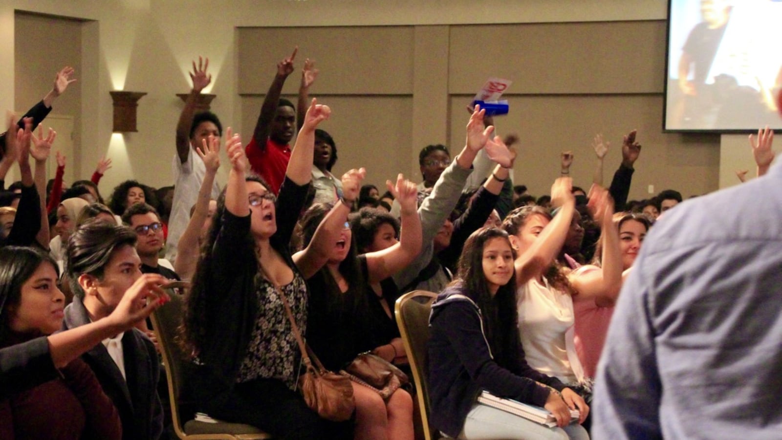 Students at a Latino Memphis conference vie for T-shirts and lanyards from local university representatives.