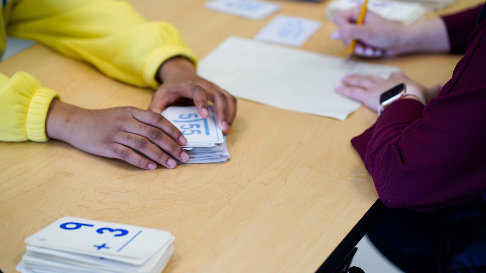 A teacher and a student in yellow work together.