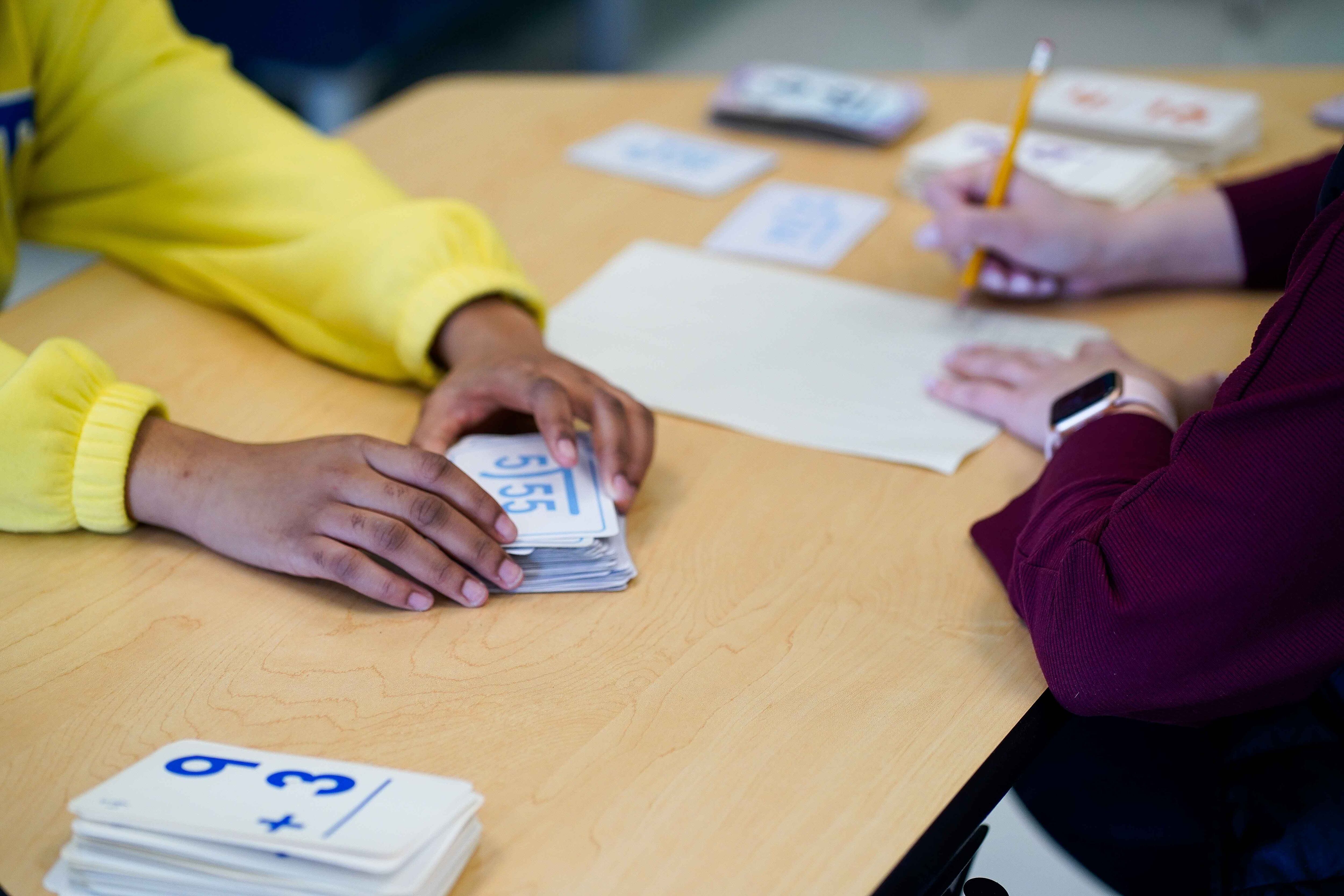 A teacher and a student in yellow work together.