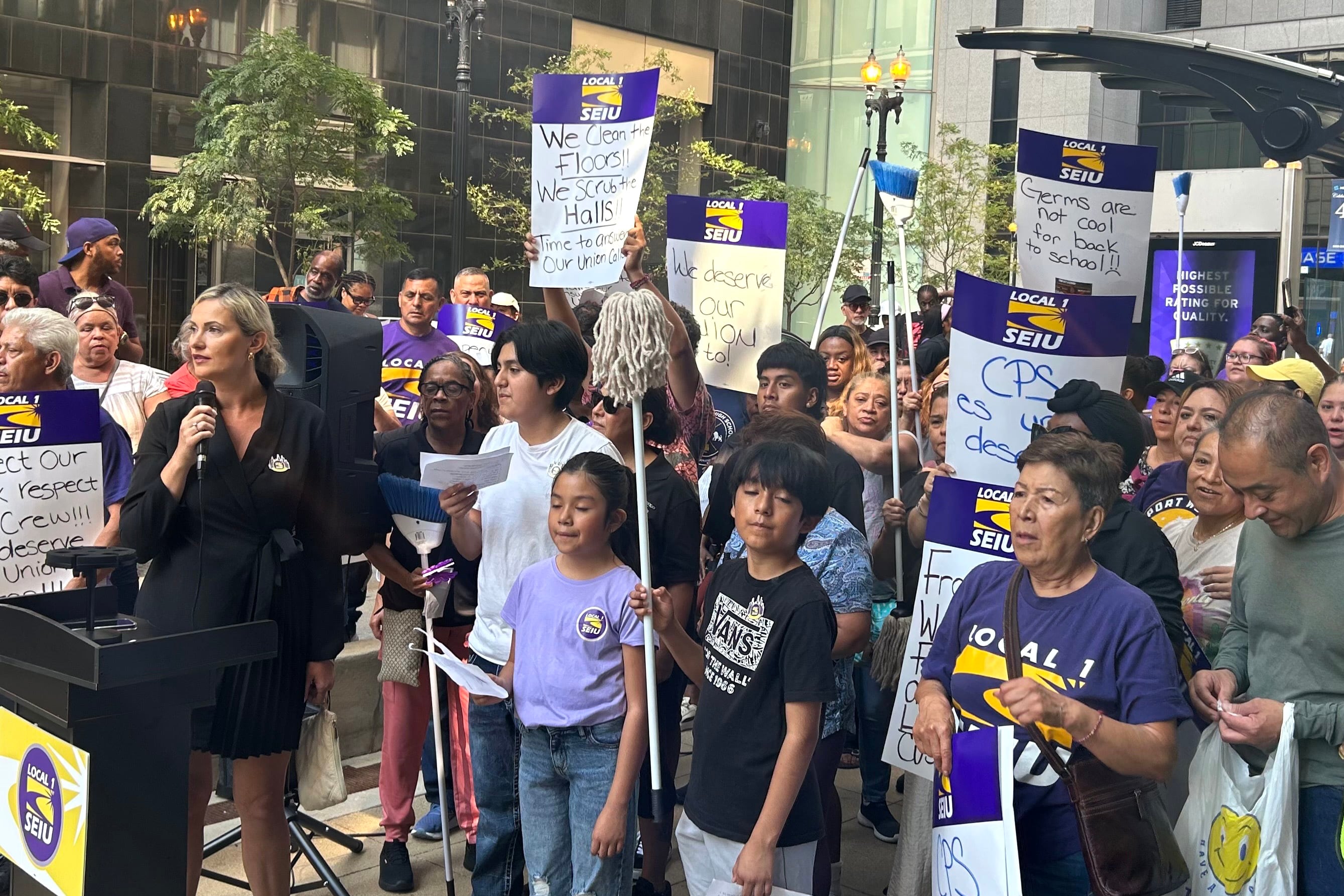 A group of people hold signs.