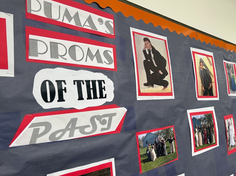 A poster on a school hallway wall that reads "Puma's Proms of the Past," with portraits of people.