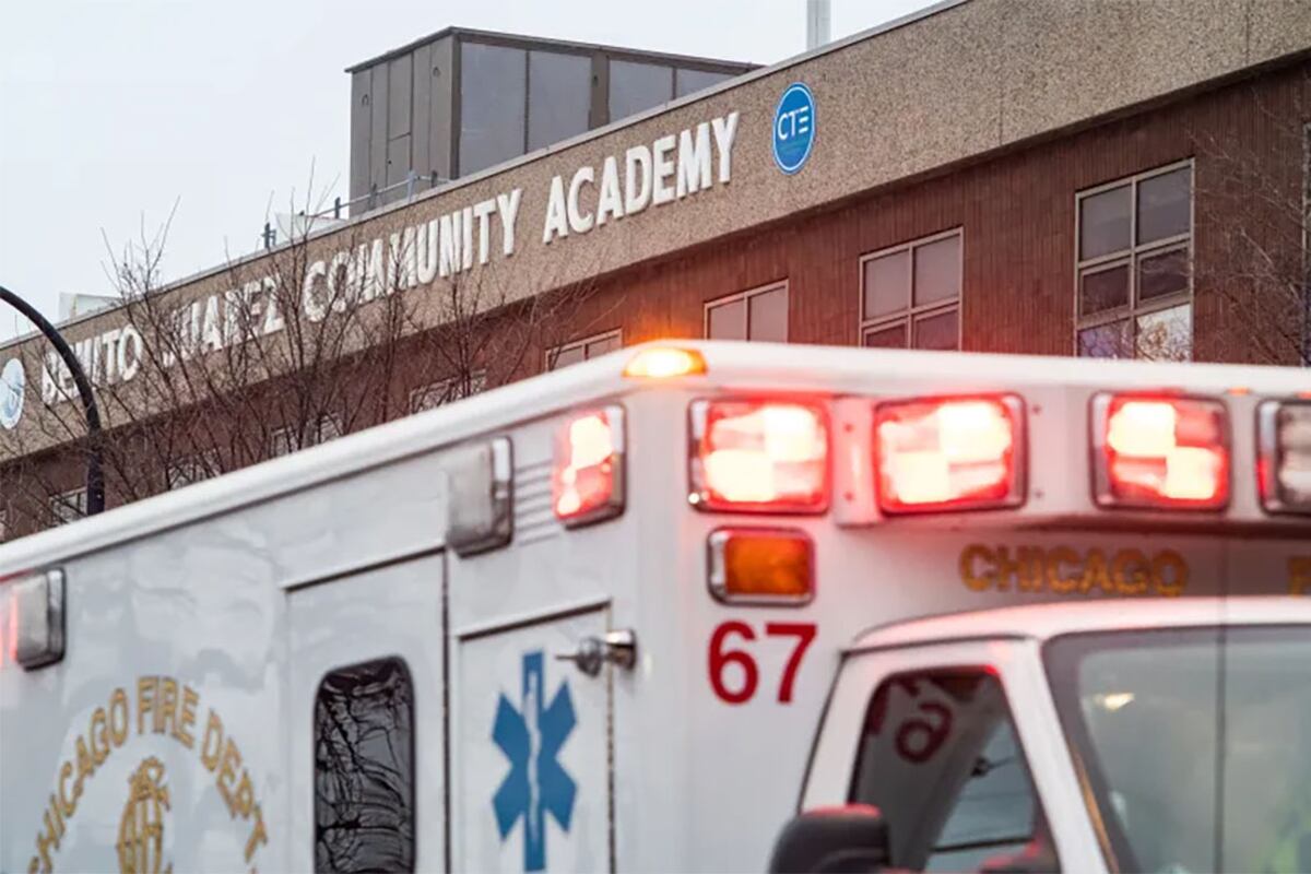 A close up of an ambulance outside of a school.