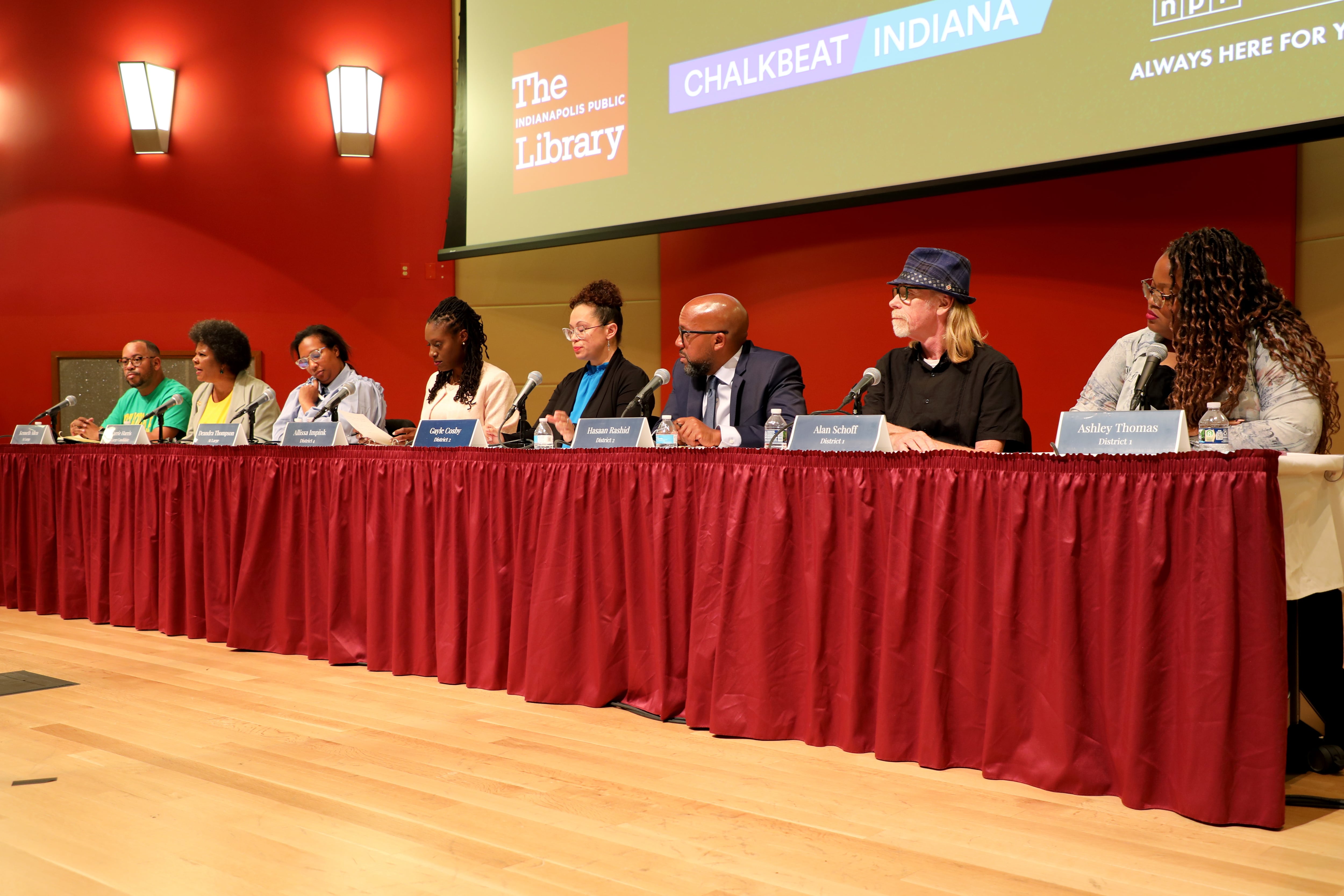 8 candidates for IPS school board sit at a table during a voter forum