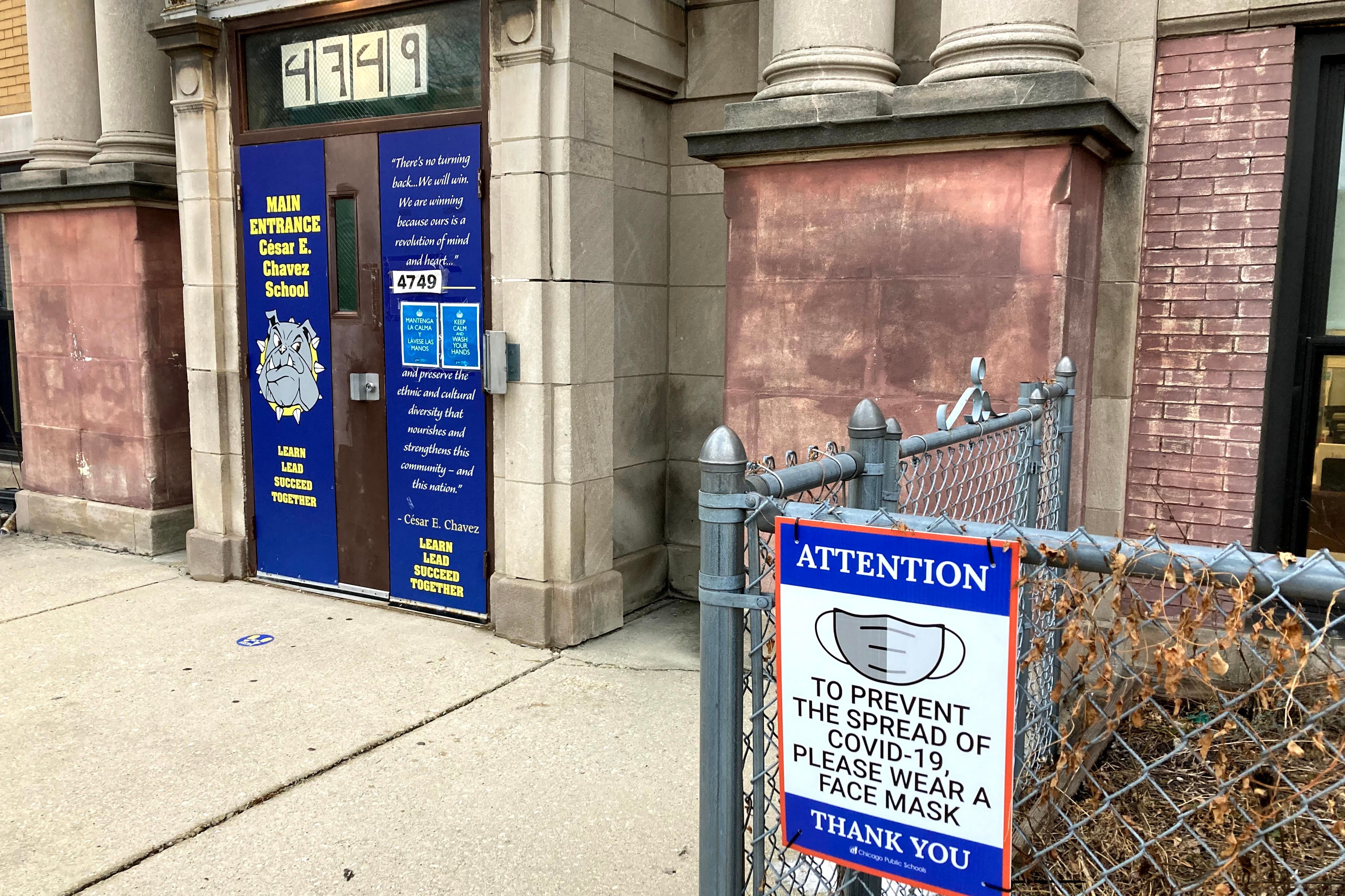 Signs posted outside a Chicago elementary school ask all who enter to wear a face mask.