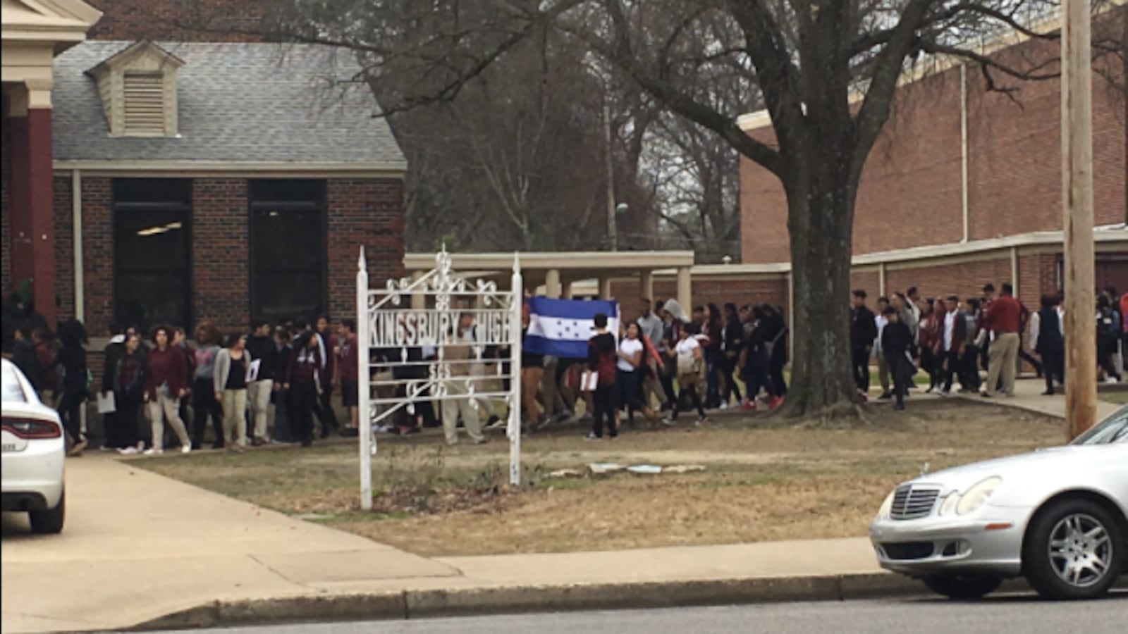Students at Kingsbury High School hold up flags as they march during a student-organized walkout on their campus in Memphis.