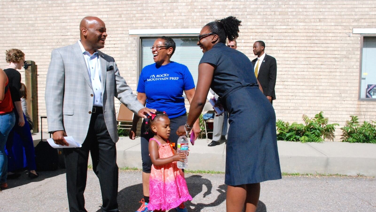 Denver Mayor Michael Hancock, left, speaks with Monica Moore, center, and Marshall Fox and her daughter Kennedy June 11 at the Hope Center Children's Program in northeast Denver. The mayor announced a campaign to renew and raise a sales tax to fund the Denver Preschool Program.
