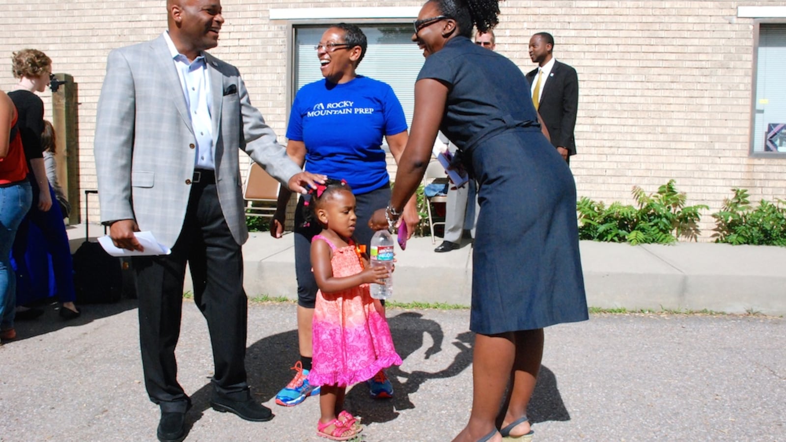 Denver Mayor Michael Hancock, left, speaks with Monica Moore, center, and Marshall Fox and her daughter Kennedy June 11 at the Hope Center Children's Program in northeast Denver. The mayor announced a campaign to renew and raise a sales tax to fund the Denver Preschool Program.
