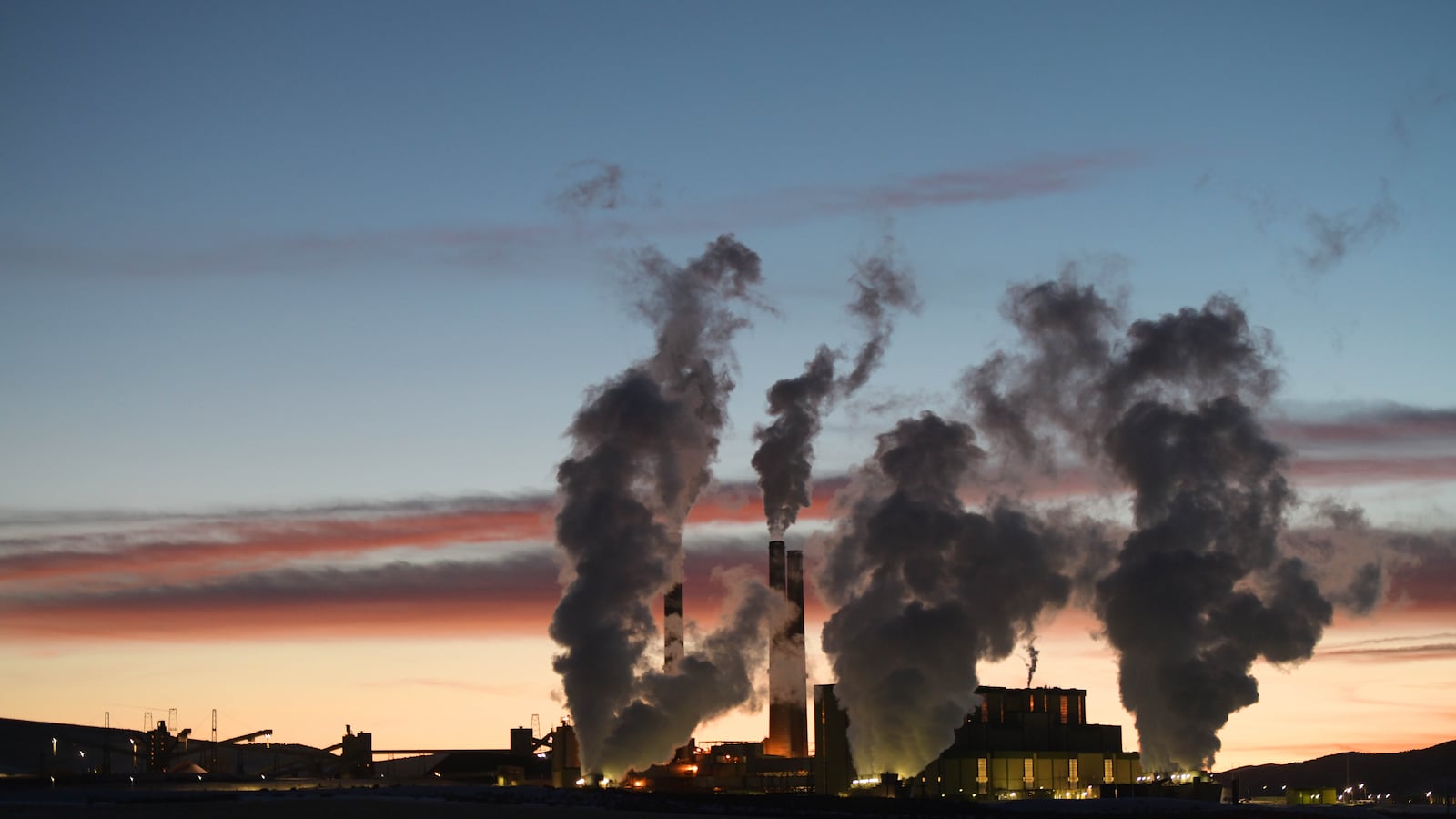 Plums of smoke rise from from the Craig Station coal-burning power plant, against a setting sun.