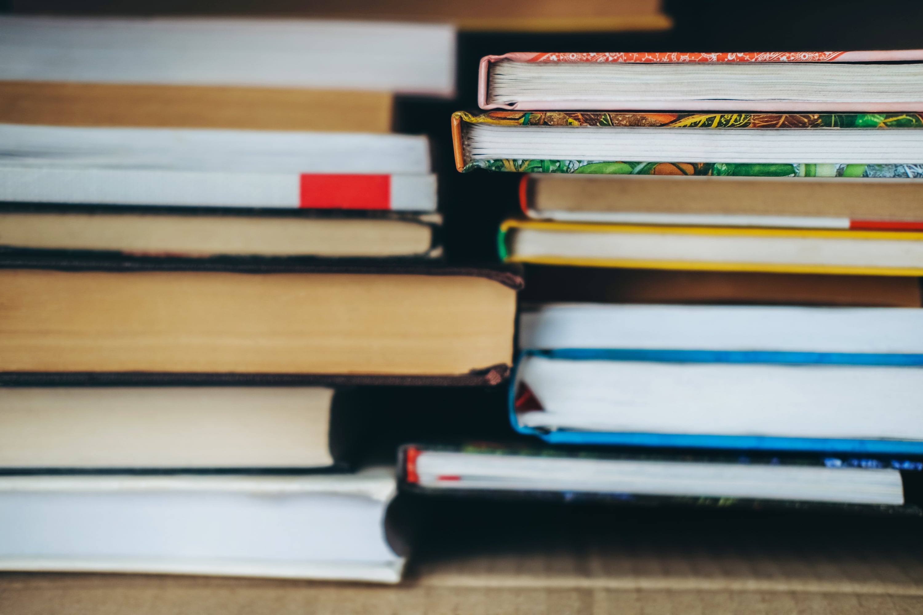 Two stacks of books in a row on a table.