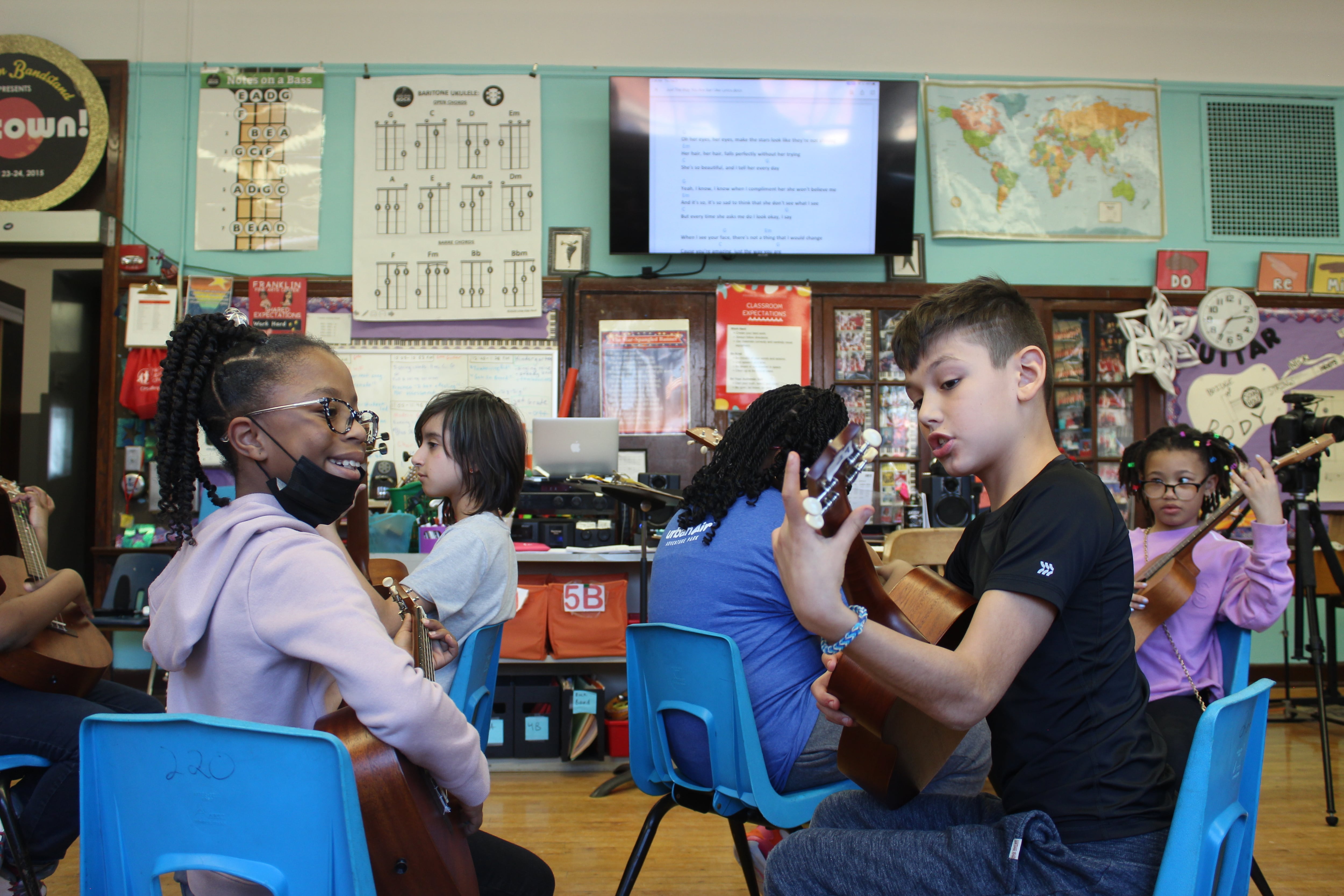 Students practice ukulele in pairs inside Franklin Fine Arts Centers on Chicago’s North Side.