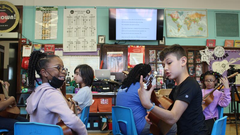 Students practice ukulele in pairs inside Franklin Fine Arts Centers on Chicago’s North Side.