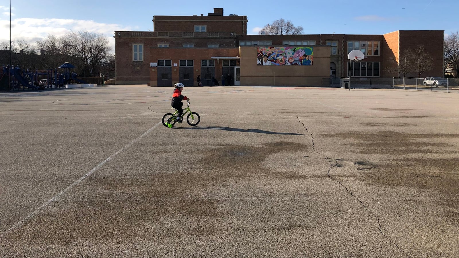 A child rides a bicycle at a shuttered Chicago public school the first week that campuses closed.