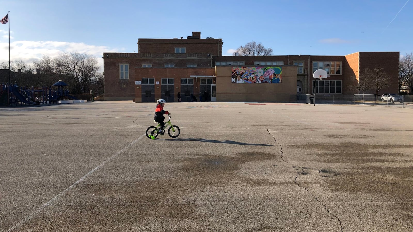 A child rides a bicycle at a shuttered Chicago public school the first week that campuses closed.