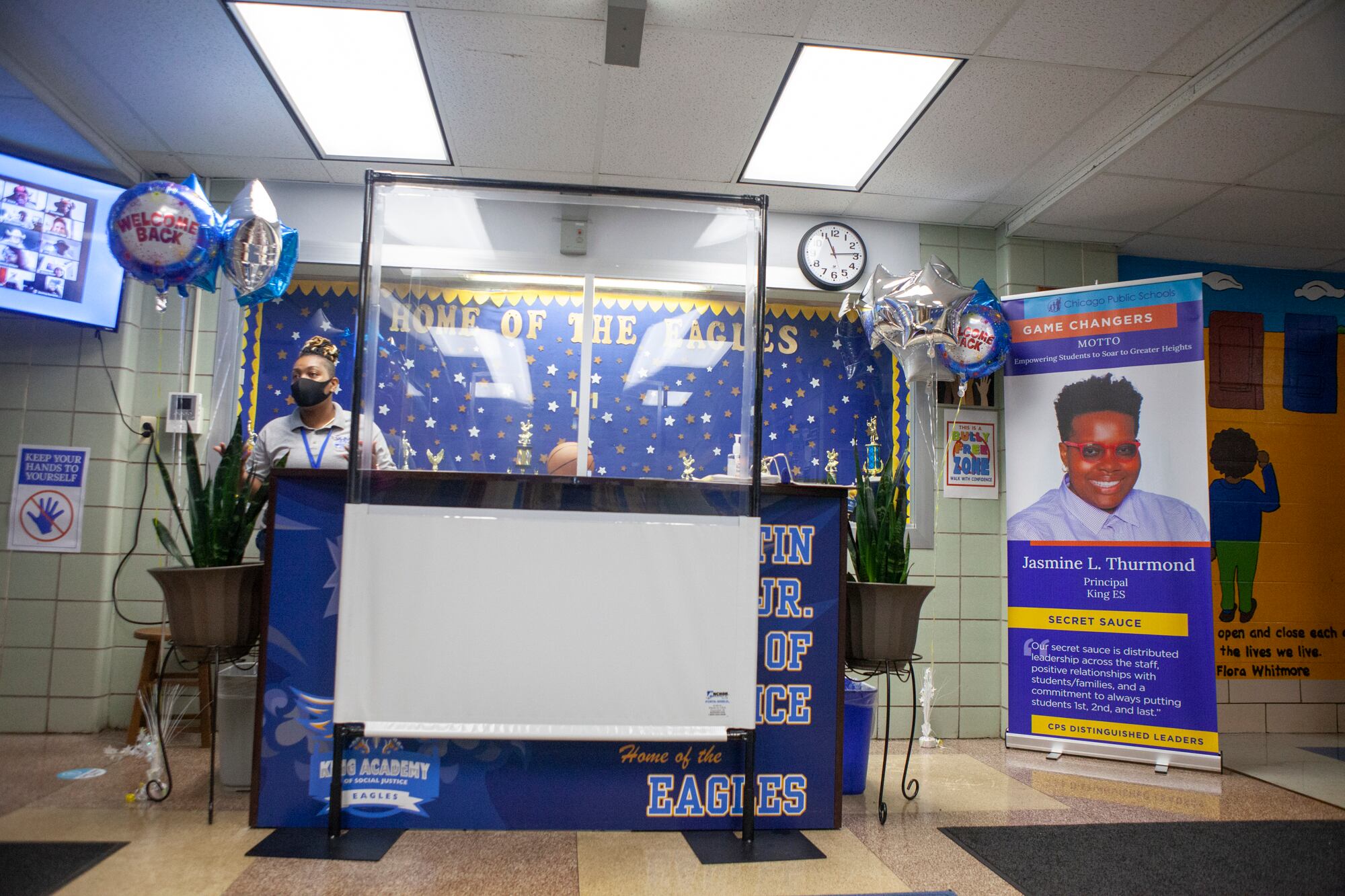 A health screening station with balloons that read welcome back.
