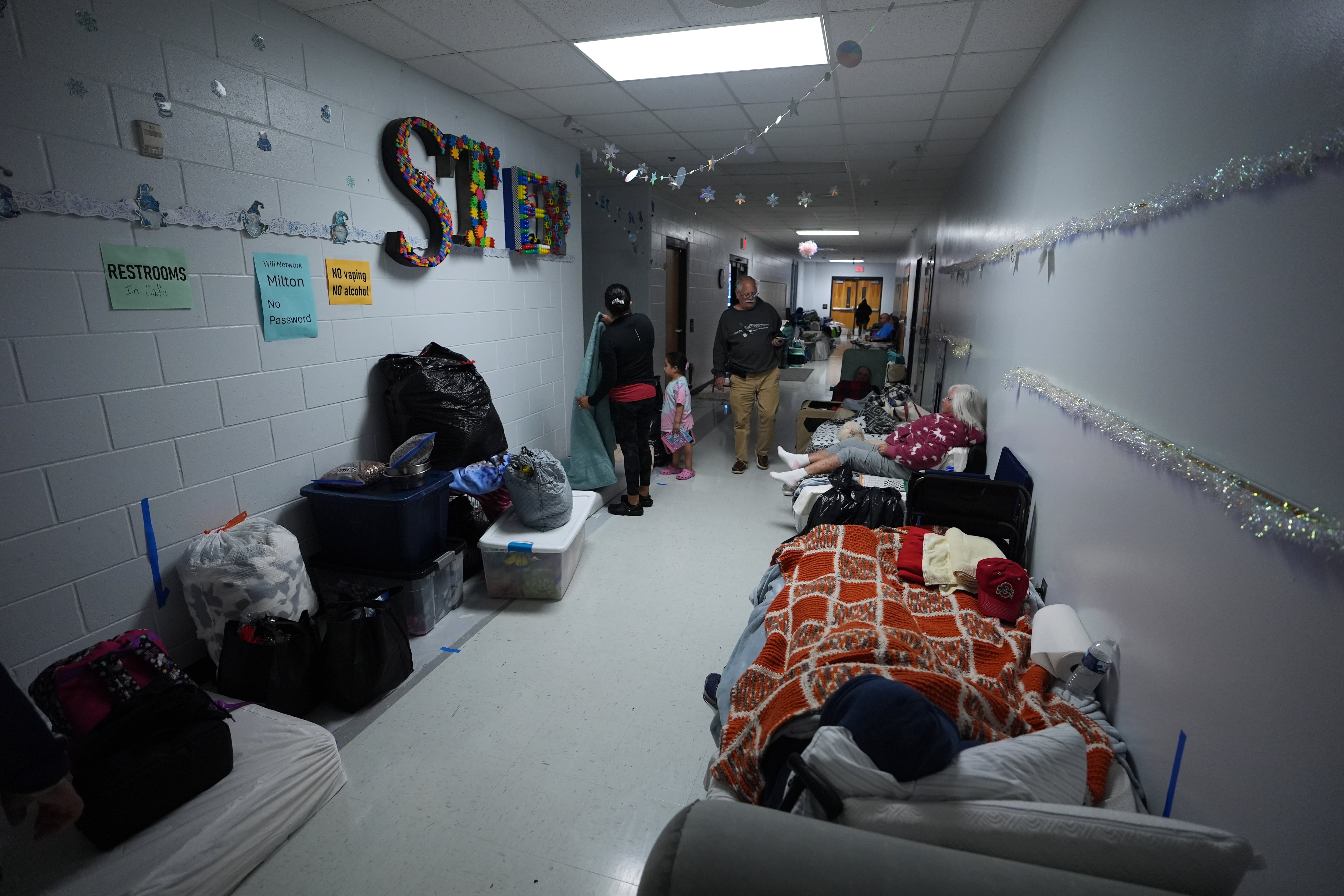 People rest along the hallways of a school