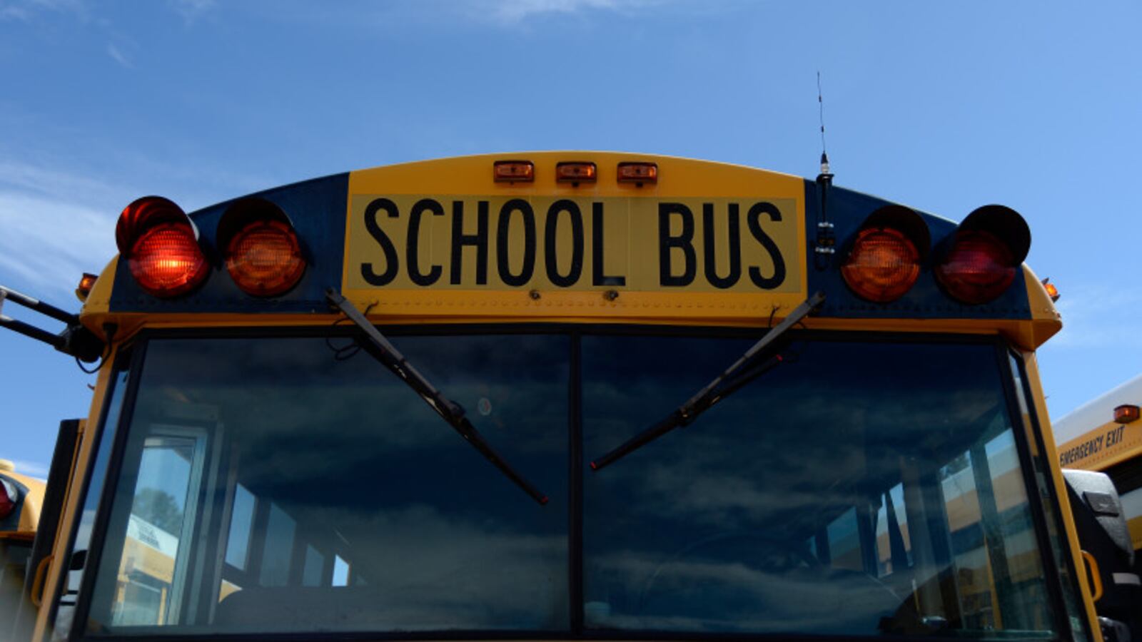Looking head-on at the front of a yellow school bus.