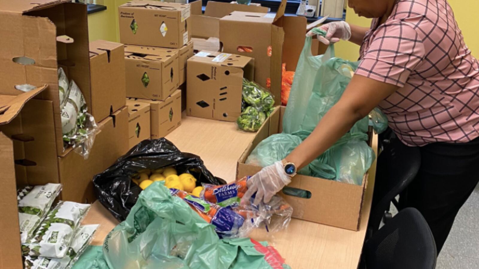 A Technology High School volunteer prepares a bag of food in Newark.