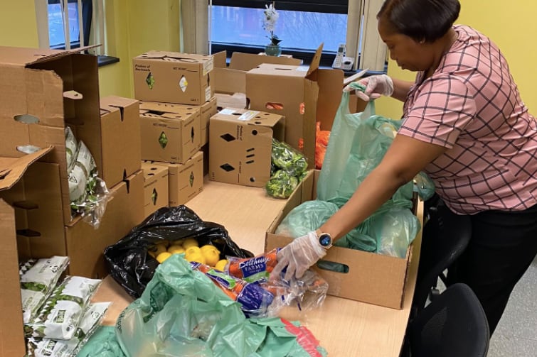 A Technology High School volunteer prepares a bag of food in Newark.