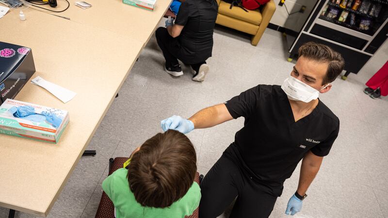A medical professional administers a COVID test to a child.