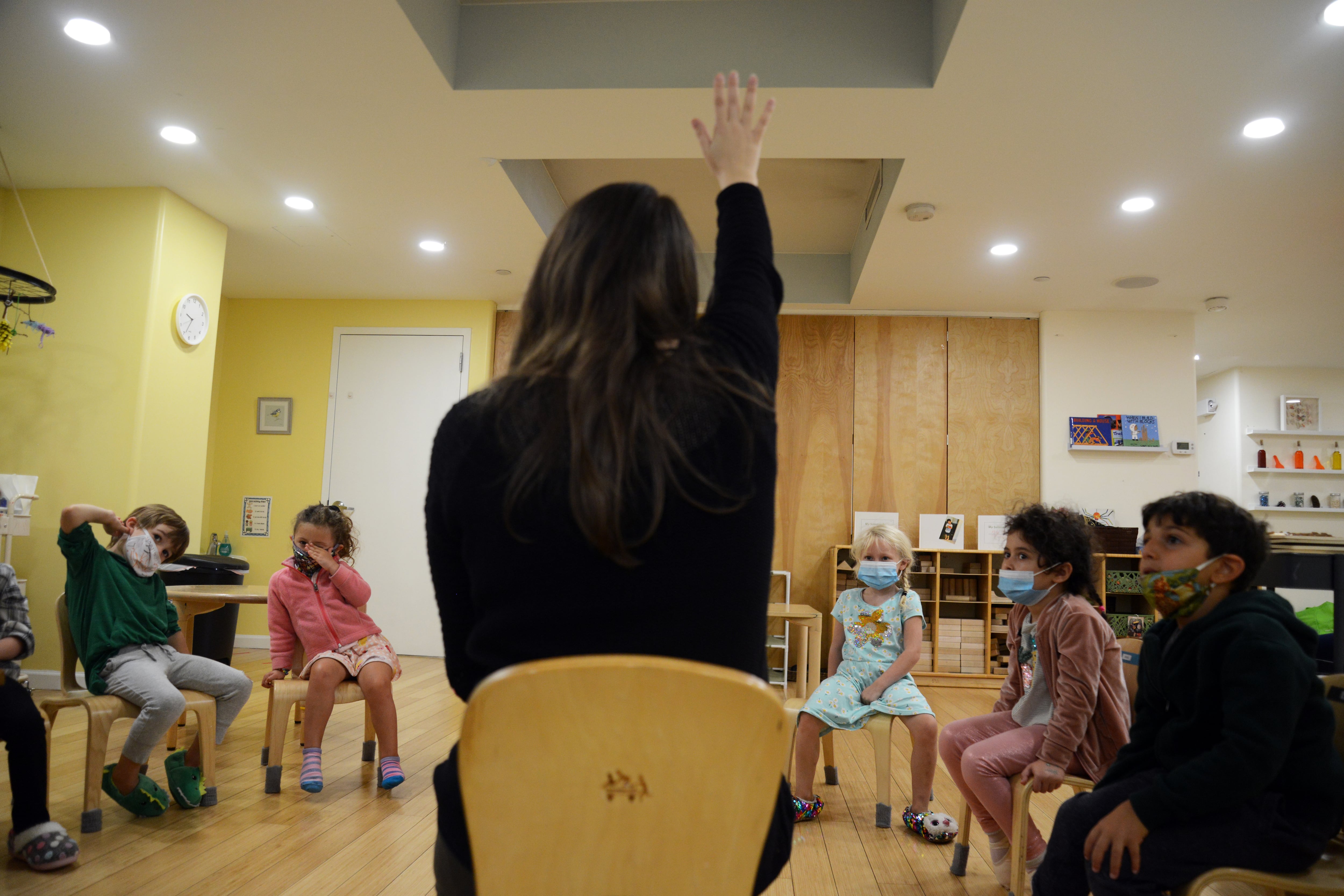 Masked preschoolers participate in a lesson on the first day of school in New York City in September. COVID-19 has ushered in long lists of safety precautions — and continual disruptions to districts that have moved forward with in-person learning.