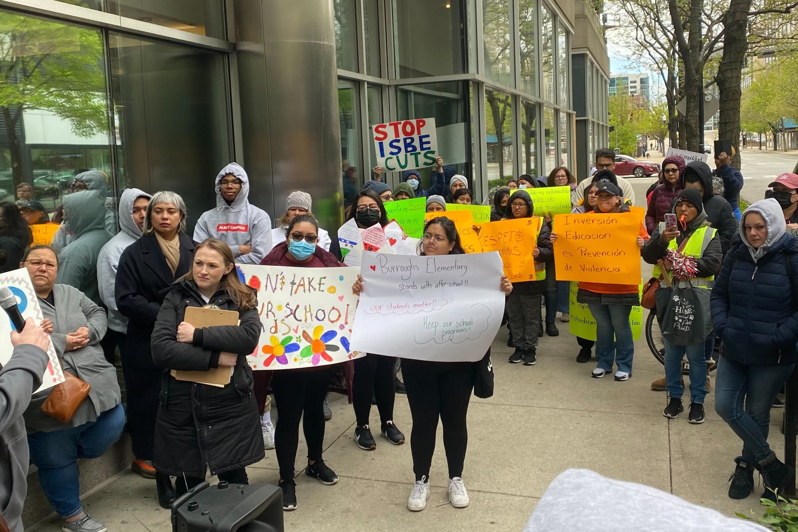 A group of advocates gathered in front of a building with signs to ask state lawmakers for funding about for after-school programs
