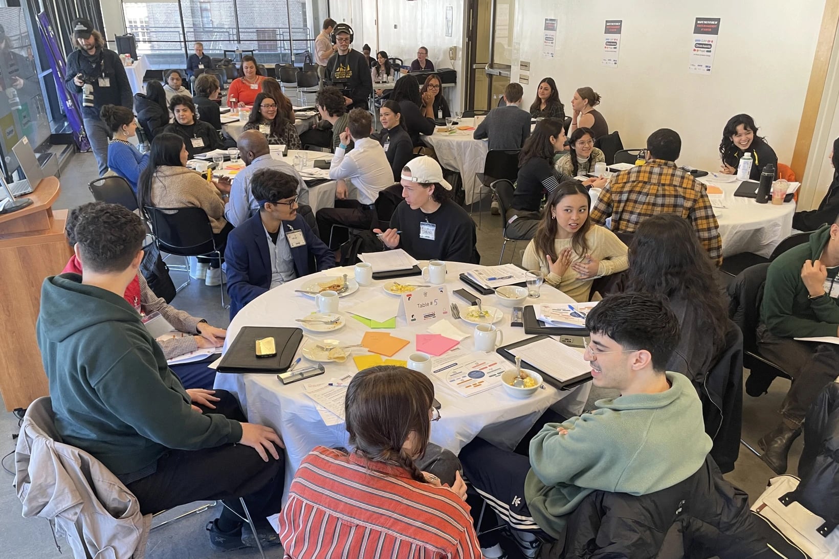 A group of people at a round table talking to each other.