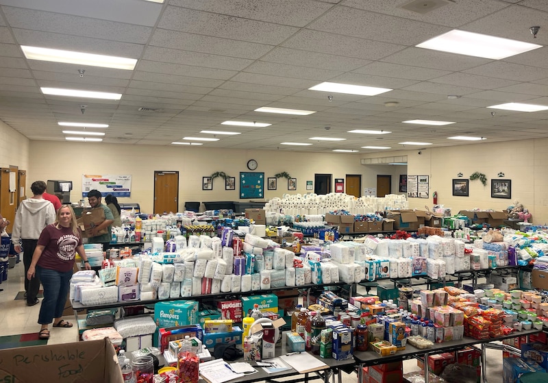 Rows of tables full of donated items in a school cafeteria.