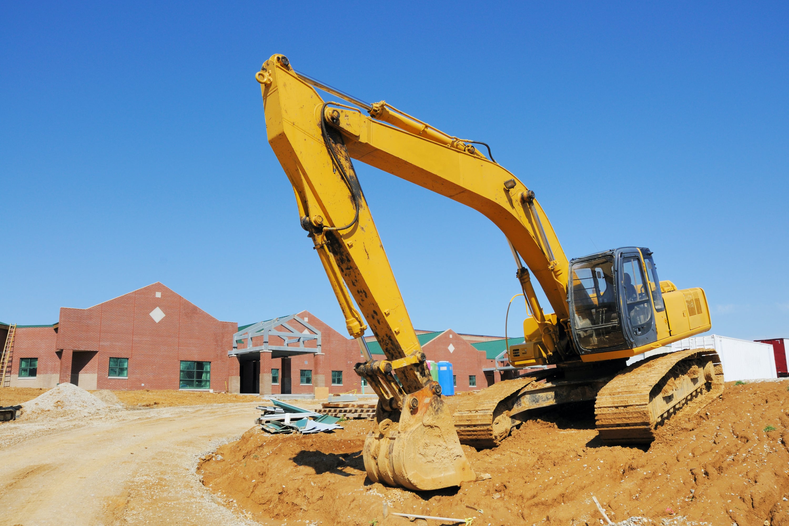 A bulldozer moves dirt at a school construction site.