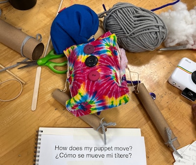 A colorful, handmade puppet on a school desk.