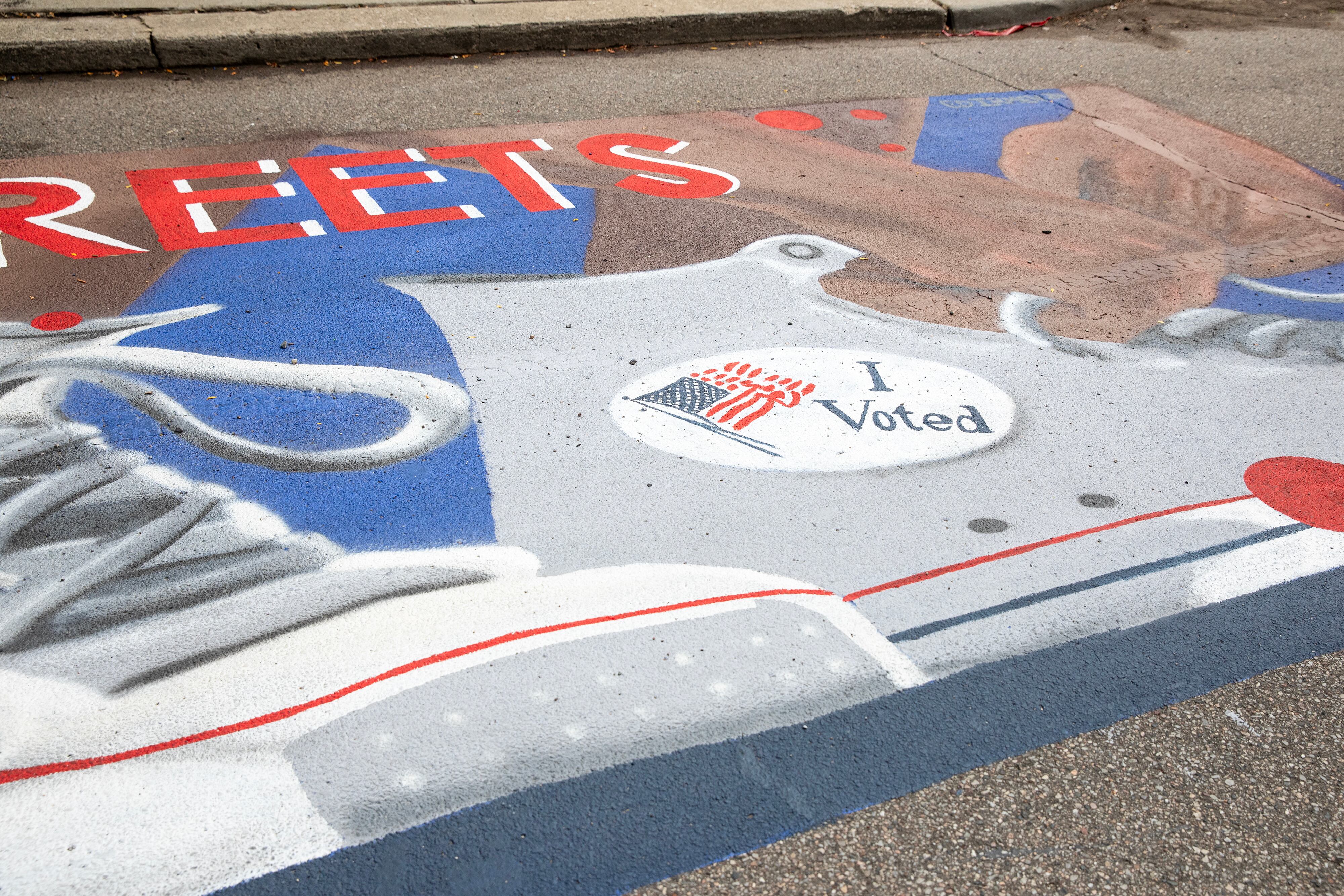 A red, white and blue mural painted on the street.