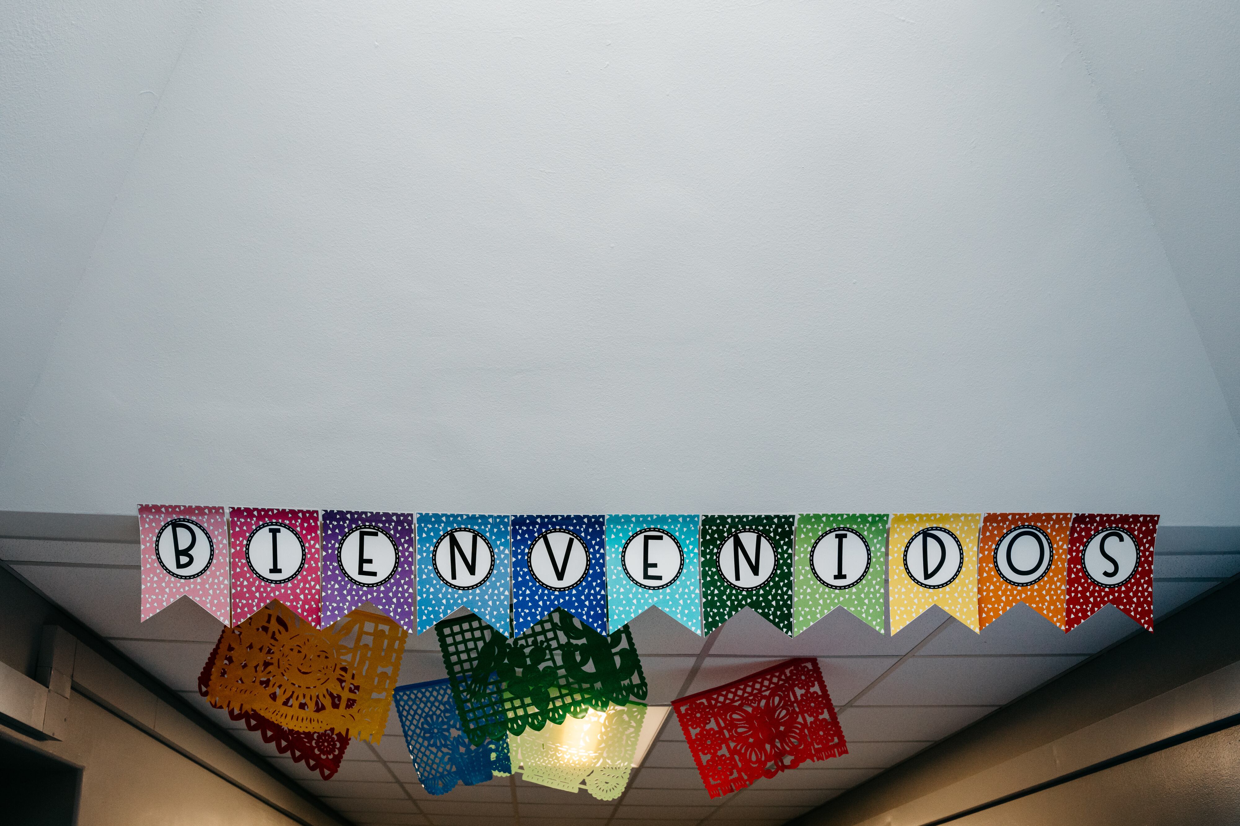 A colorful banner hanging from the ceiling that says "Bienvenidos," which is welcome in Spanish.
