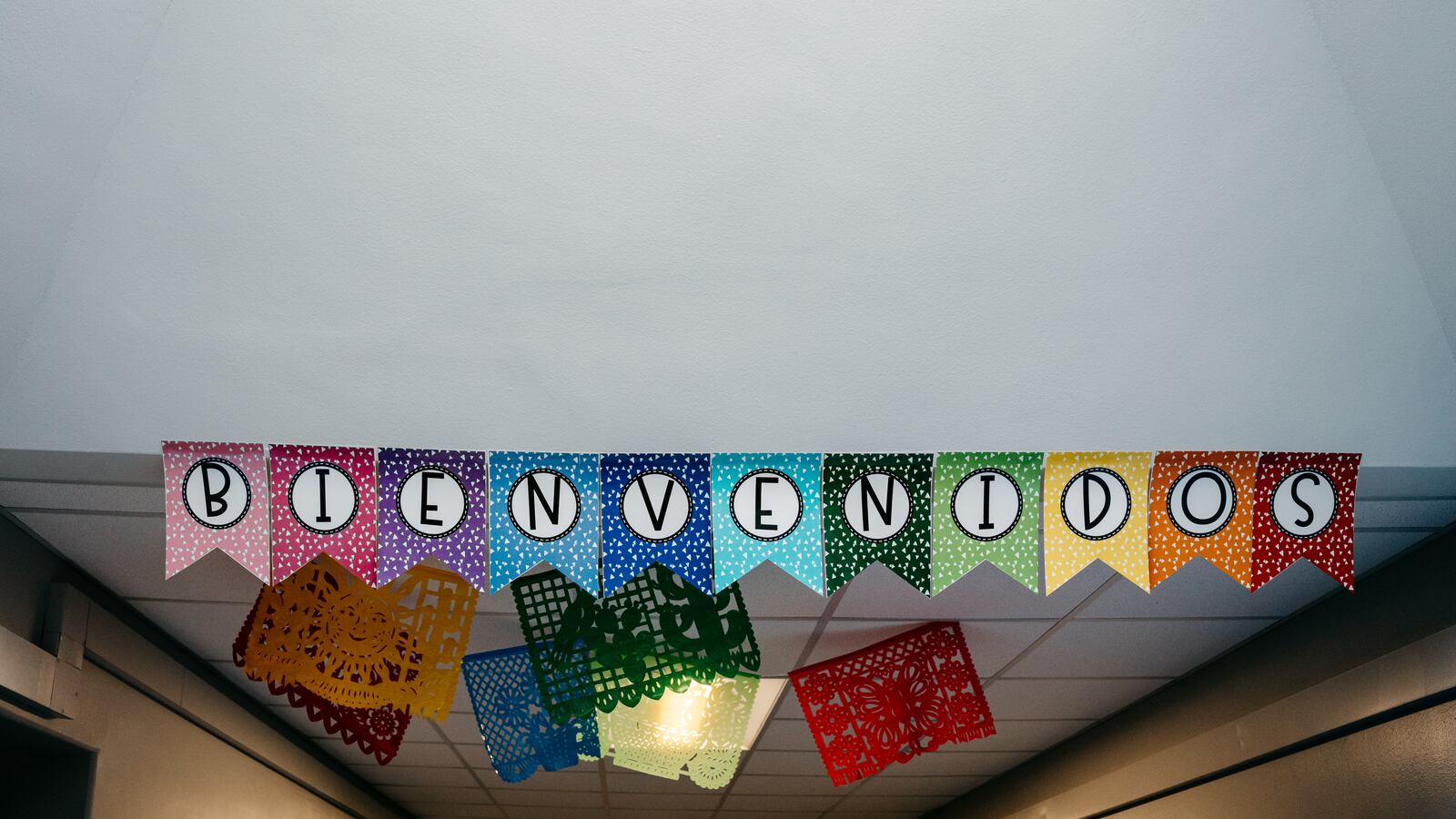 A colorful banner hanging from the ceiling that says "Bienvenidos," which is welcome in Spanish.