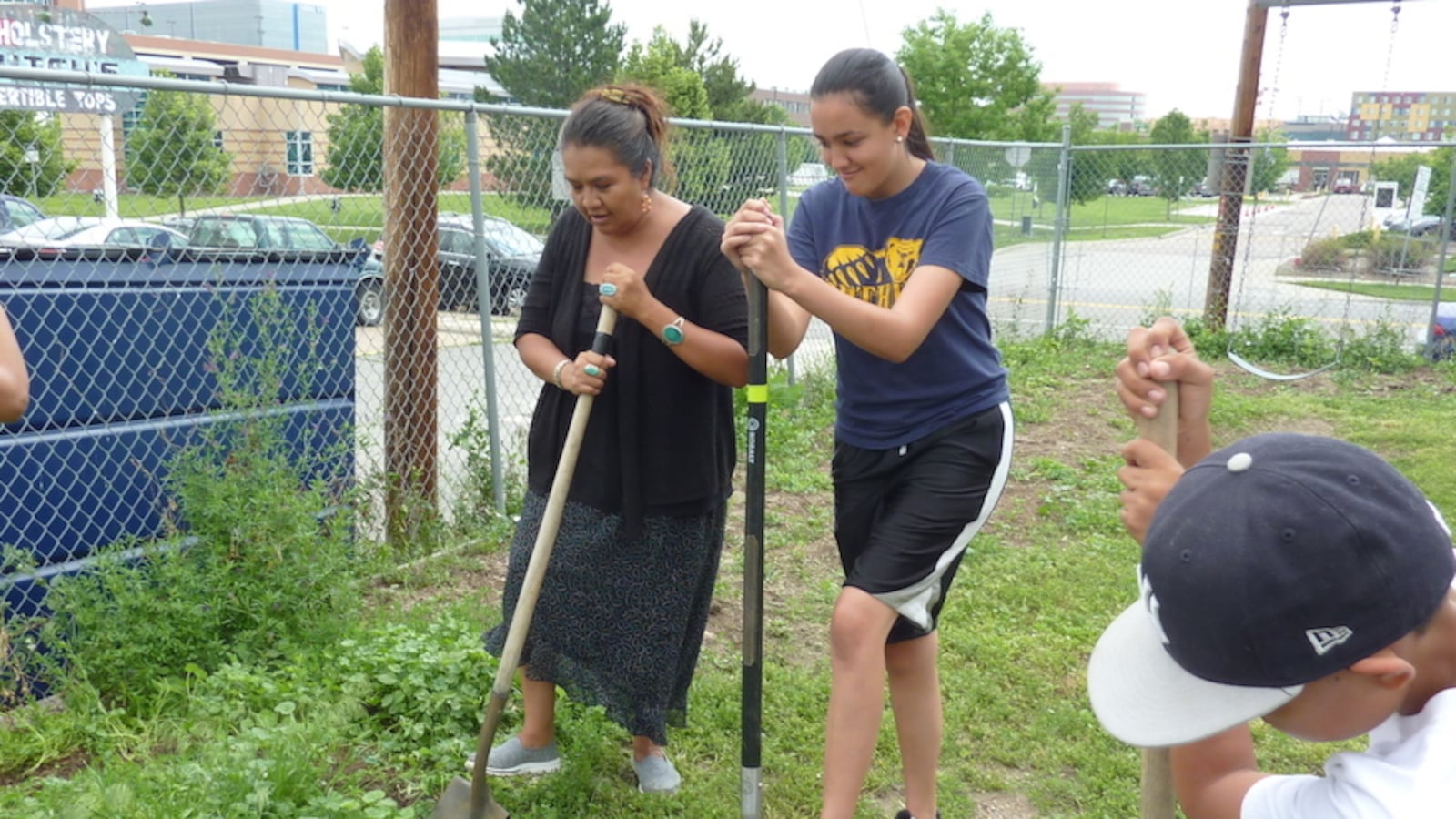 Shannon Francis and Taloa Cardinal, 15, turn soil in preparation for a garden expansion.