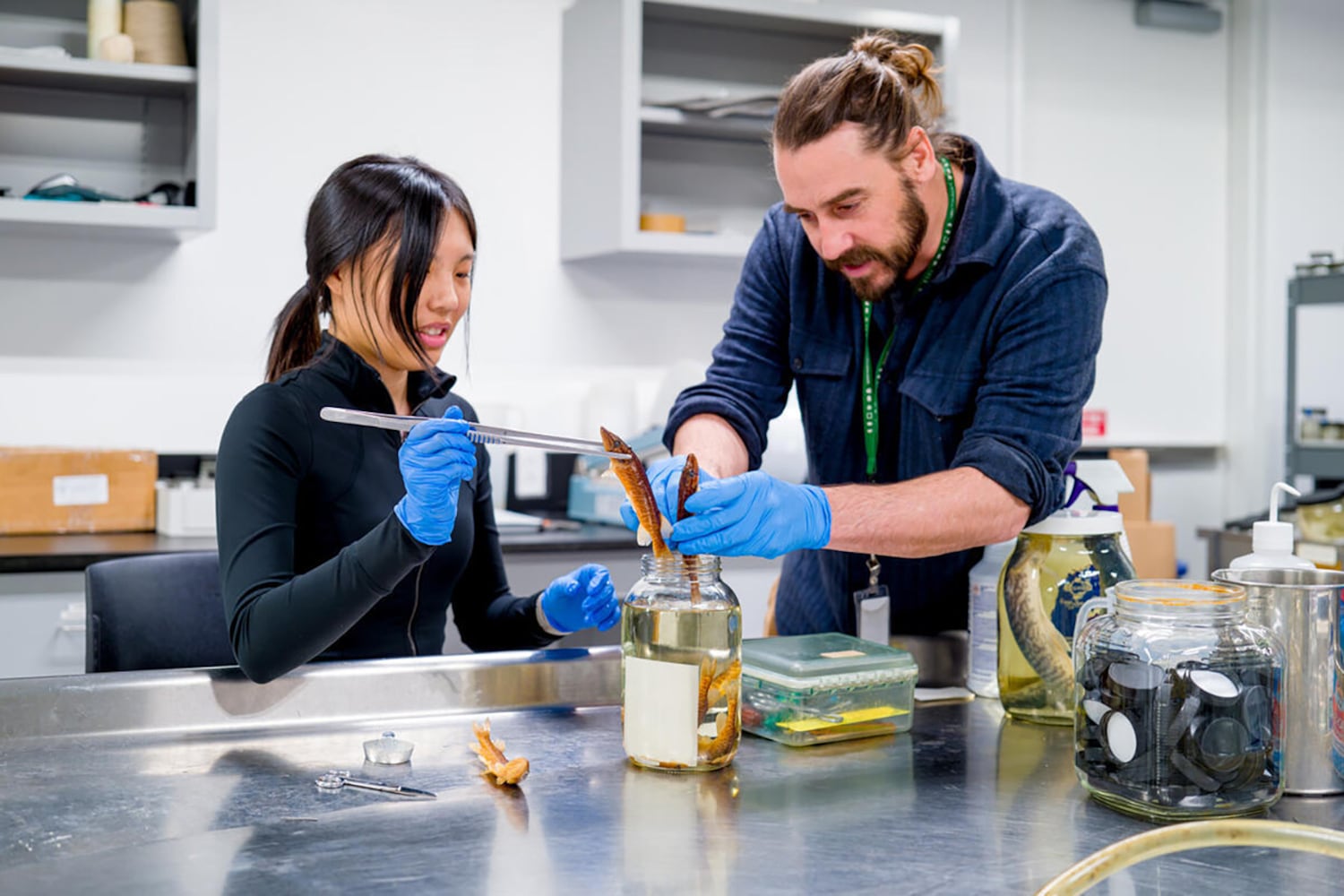 A man with a blue shirt works with a female student in a blue shirt.