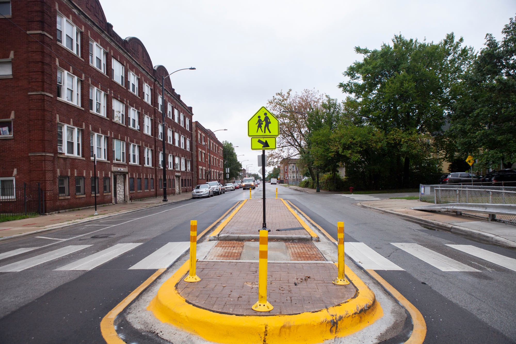 A school crossing sign in a cross walk.