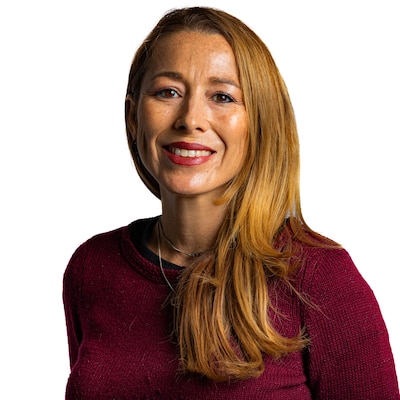 Headshot of a woman with strawberry blond hair wearing a maroon sweater