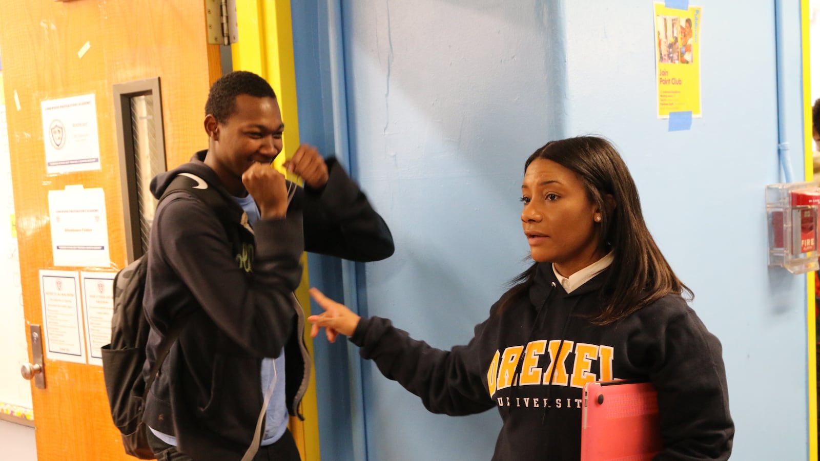 Principal Asya Johnson of Longwood Preparatory Academy, a community school, corrals a student between classes.