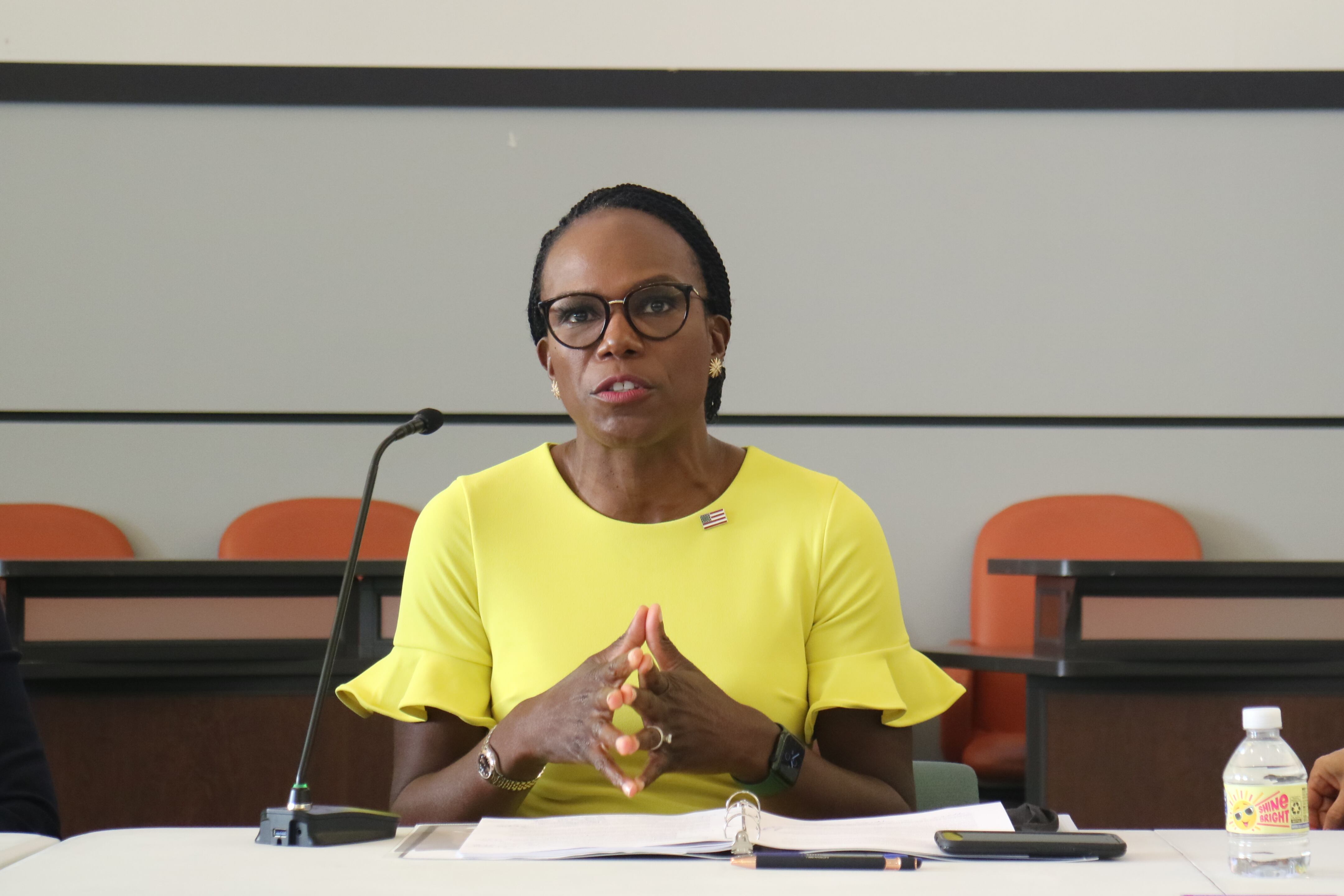 Dr. Ala Stanford in a bright yellow dress speaks on a panel.