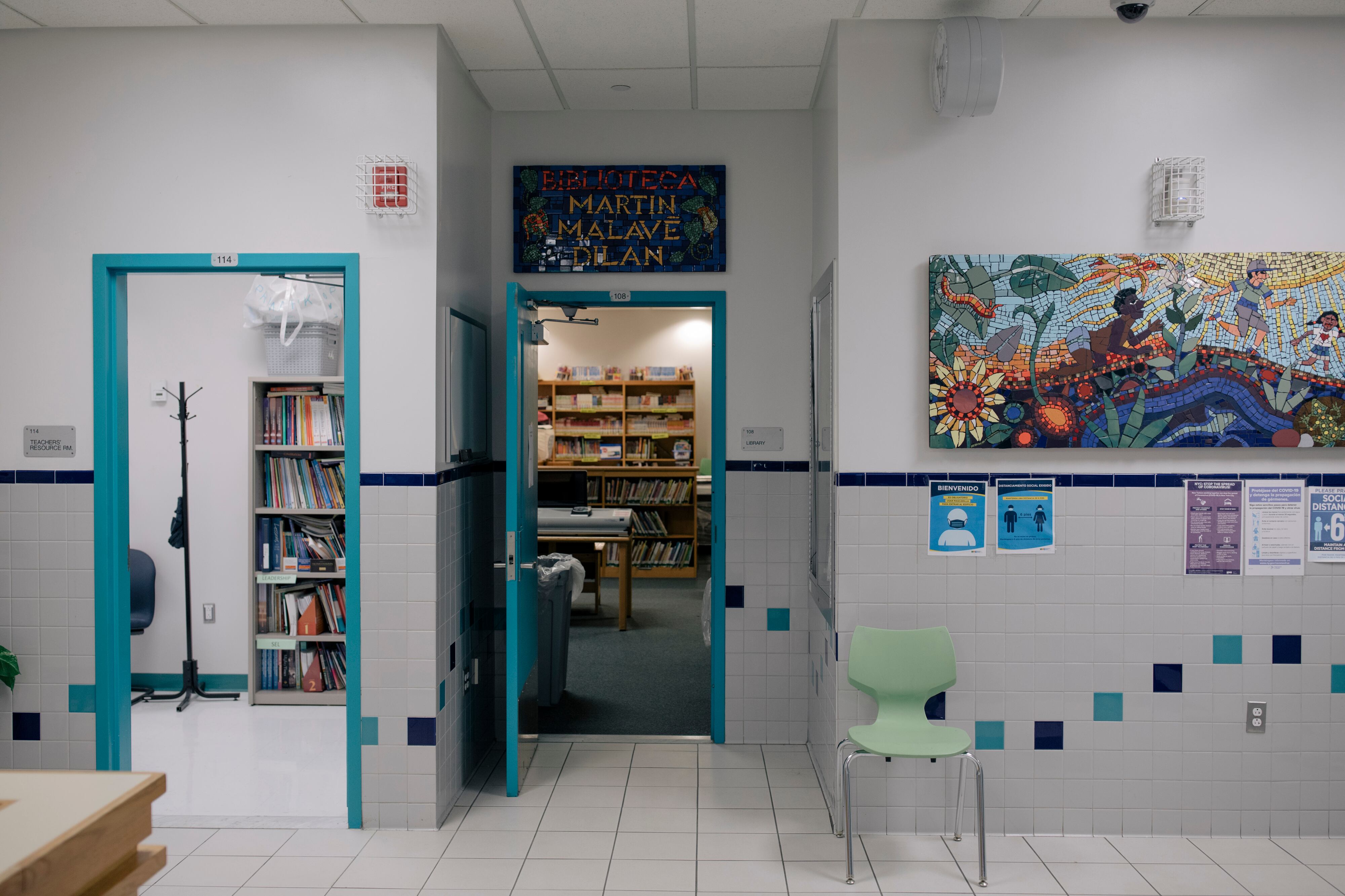 A photograph of a school lobby with colorful drawings on the wall.