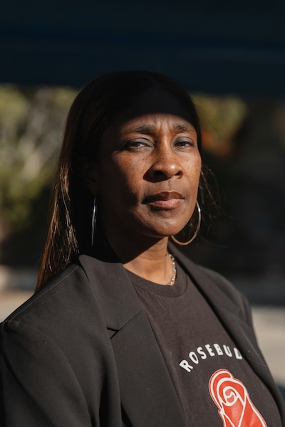 A photograph of a Black woman looking into the camera and posing for a portrait.