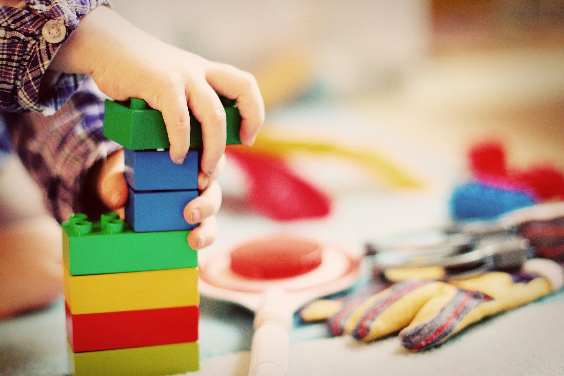 Close-up of a child’s hands building with Legos.