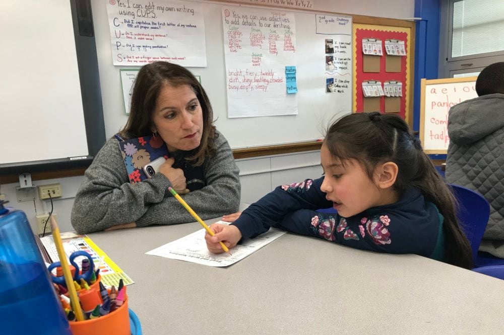 Denver Superintendent Susana Cordova leans down to watch a student work on math problems at Columbine Elementary.